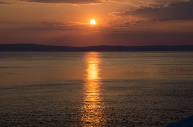 Bulutlar ve kırmızı cennet denize sıfır yukarıda günbatımı.