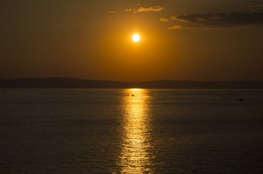 Bulutlar ve kırmızı cennet denize sıfır yukarıda günbatımı.