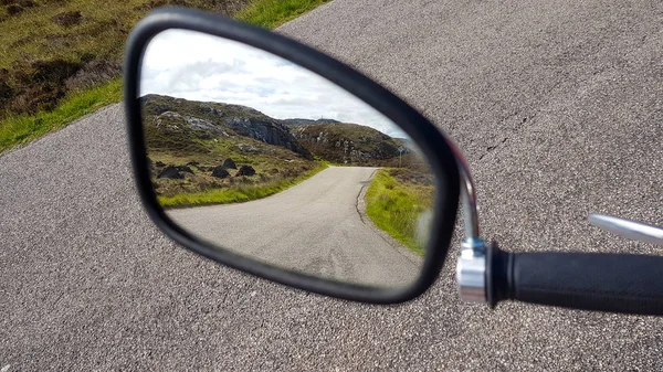 Een blik om oude motor spiegel met een weg in reflextie wazig te maken — Stockfoto