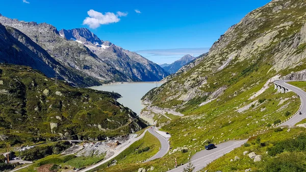 Un barrage en Suisse entre des montagnes avec de l'eau sale sous bl — Photo