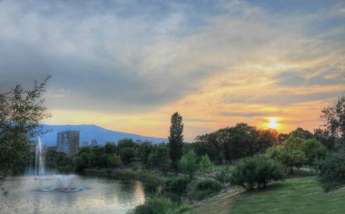 Mesafe binalarda şehir Gölü üzerinde renkli bir gün batımı