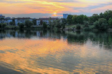 Mesafe binalarda şehir Gölü üzerinde renkli bir gün batımı