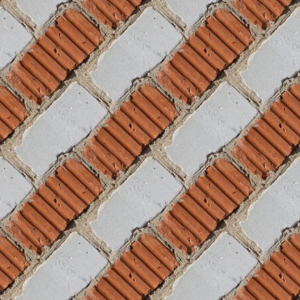 Ciment とタイルの間の小さな石の片を使用してオレンジと灰色や白いレンガの壁のデザイナーのためのシームレスなパターン — ストック写真