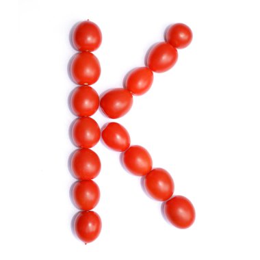 K harfi domates ile yapılır. Beyaz bir arka plan üzerinde domates İngilizce alfabe sembolü.