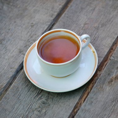 Kahvaltı için ahşap bir yüzeyde bir fincan çay. Kapat..