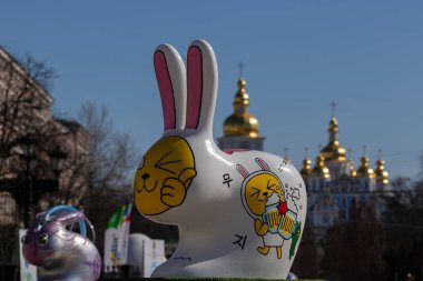 Kiev. Ukrayna - 07 Nisan 2018: Kiev Sofiyvska meydanda Paskalya Festivali. Yabani tavşan boyalı ve çok renkli Paskalya yumurta boyalı sanatçı görüntü. St Michaels Golden-Domed Manastırı Kiev içinde görülen Katedrali ve çan kulesi manzarası. Kateri