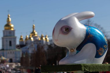 Kiev. Ukrayna - 07 Nisan 2018: Kiev Sofiyvska meydanda Paskalya Festivali. Yabani tavşan boyalı ve çok renkli Paskalya yumurta boyalı sanatçı görüntü. St Michaels Golden-Domed Manastırı Kiev içinde görülen Katedrali ve çan kulesi manzarası. Kateri