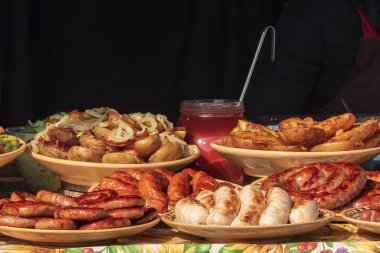 Etli, sosisli ve ızgara sebzeli çeşitli sağlıklı yiyecekler sunan bir açık büfe. Açık havada mutfak..