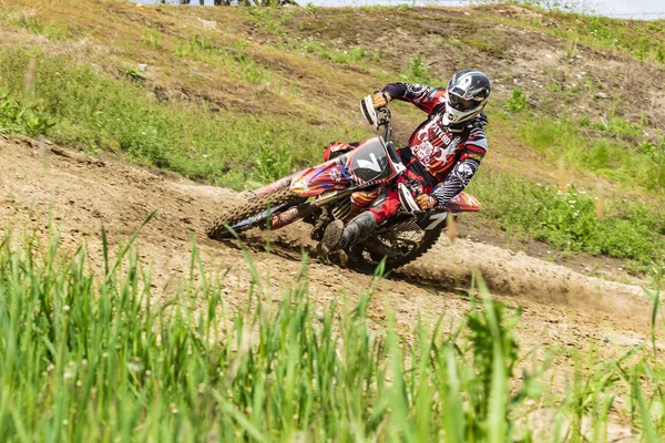 Motocross. Motorcyclist in a bend rushes along a dirt road, dirt flies from under the wheels. Close-up. Active extreme rest.