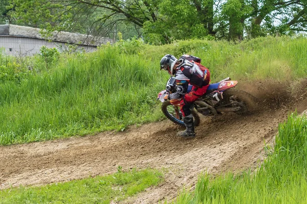Motocross. Motorcyclist in a bend rushes along a dirt road, dirt flies from under the wheels. Close-up. Active extreme rest.