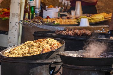 Sağlıklı yiyeceklerle servis edilen açık büfe. Plov, pilav, et, biber, baharat, ızgara sebze. Sokaklarda balık ve et, yiyecek pazarı, festival, etkinlik. Açık havada mutfak..
