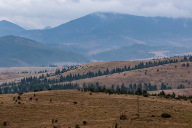 Yüksek dağların tepeleri bulutlarla gizlidir. Sis. Sonbahar manzarası. Panoramik görünüm.