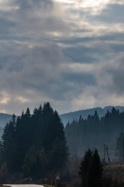Yüksek dağların tepeleri bulutlarla gizlidir. Sis. Sonbahar manzarası. Panoramik görünüm.