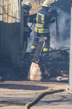 Güçlü ve cesur bir itfaiyeci yangın operasyonunda suyu kullanarak yanan bir binayı kurtarır. Yangın koruma giysisi giymiş bir itfaiyeci. Gerçek bir yangının söndürülmesi..