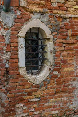 İtalya, Venedik 'in tuğla duvarında küçük kemerli bir pencere bulunur. Yıpranmış taşlar ve paslı çubuklar yaşın ve gücün hikâyelerini anlatır. Duvar, unutulmuş zamanların cazibesini ve sessizliğini taşıyor..