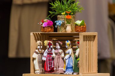 Geleneksel Ukrayna bebeklerinin canlı bir gösterisi ahşap bir stantta düzenlenir. Her bebek benzersiz desenler, çiçekler ve halk mirasını yansıtan canlı kumaşlar taşıyor.. 