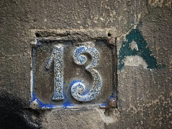 Vintage grunge square metal rusty plate of number of street address with number closeup