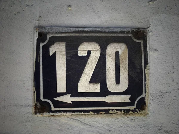 Vintage grunge square metal rusty plate of number of street address with number closeup