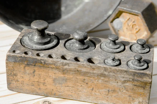 Old rusty scale weight on wooden table, Old rusty iron scale weight