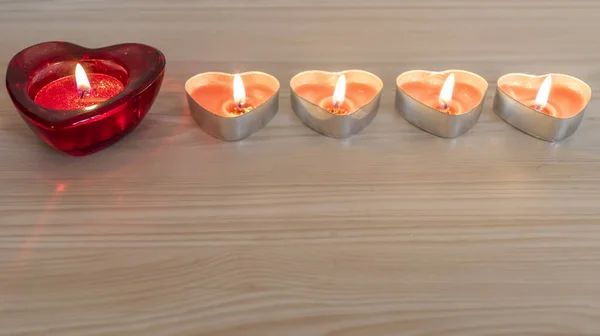 Mum içinde bir ahşap doku arka plan üzerinde yanan ile kalp şekli. Sevgililer günü kavramı.