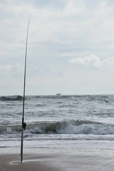 Fishing Boat and Fishing Pole, rough seas. Florida beach. Pacific Ocean