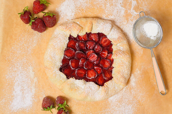 homemade strawberry Galette with fresh ripe strawberries on a dark background.