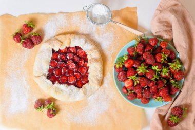 Taze olgun çilekli ev yapımı çilekli bisküvi. Parşömen üzerinde, açık arkaplan, üst görünüm..