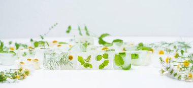 Papatyalı kozmetik buz küpleri ve evde bakım için nane şekeri yüz için kullanılır. Cilt bakımı kavramı. Hafif arka planda bitkilerle kozmetik ürünleri