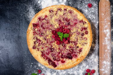 Ahududu turtası ve olgun ahududu evde pişiyor. Koyu arka planda süzme peynirle pişiriliyor. Metinler için en iyi manzara..