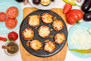 Bir ısırık için patlıcanlı ev yapımı vejetaryen pizza tarifi, domates, biber, mozzarella. Yukarıdan manzaralı pizza hazırlayan bir kadının elleri. ışık arkaplanı