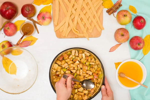 Autumn baking concept. step-by-step recipe for baking a traditional autumn Apple pie, copy the space on a light background. knead the dough and pour the apples into the dough.