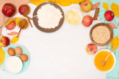 Elma gevreği, adım adım tarifi ve arka planda hafif bir ev yemeği için malzemeler. Tarçın ve yulaf ezmeli geleneksel sonbahar tatlısı, tatlım.