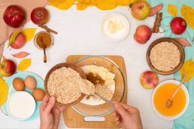 Elma gevreği, adım adım tarifi ve hafif arka plan manzaralı ev yemeği malzemeleri karışımı. Tarçın ve yulaf ezmeli geleneksel sonbahar tatlısı, tatlım..