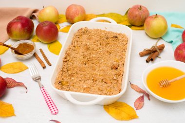 Hafif arka plan manzaralı ev yemeği için elmalı gevrek. Tarçın ve yulaf ezmeli geleneksel sonbahar tatlısı, tatlım.