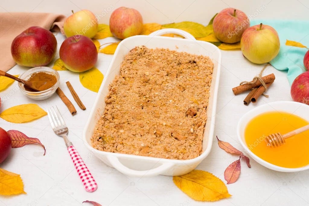 Apple crisp crumble for home cooking on a light background top view. traditional autumn dessert with cinnamon and oatmeal, honey