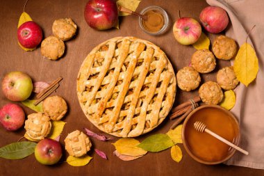 Mevsimlik elma ve tarçınlı sonbahar pişirme konsepti. Elmalı turta, çörek, gevrek, kek, kek. Sonbahar sarı yapraklı ahşap bir arka planda üst manzara