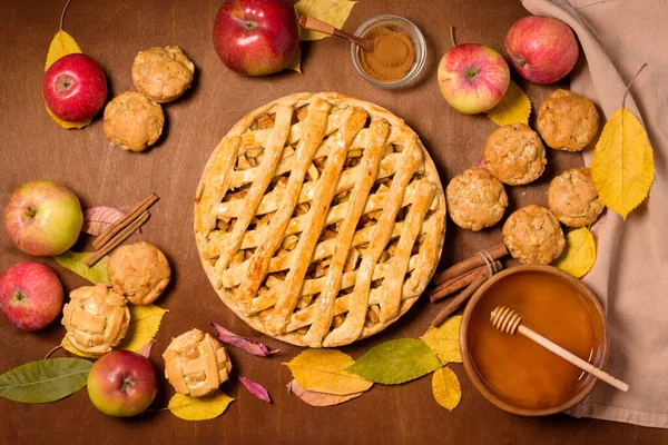 Mevsimlik elma ve tarçınlı sonbahar pişirme konsepti. Elmalı turta, çörek, gevrek, kek, kek. Sonbahar sarı yapraklı ahşap bir arka planda üst manzara