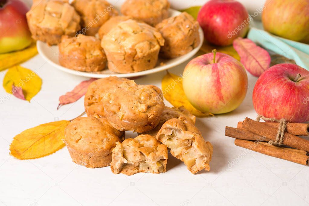homemade Apple cupcakes and muffins, light background, yellow leaves. the concept of fall baking and fall harvest. cupcake is broken into pieces, filling with Apple.