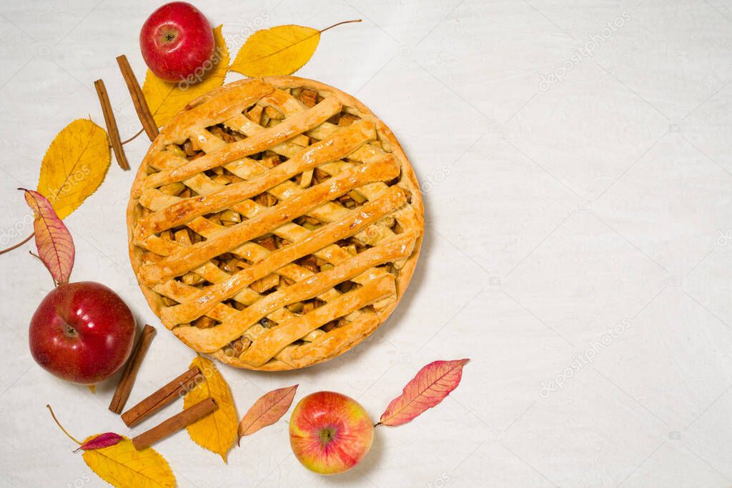 autumn baking concept with seasonal apples and cinnamon honey. Apple pie top view on a light background with autumn yellow leaves