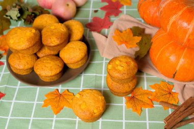 Mevsimlik balkabağı ve tarçın baharatlarıyla balkabağı kekleri pişirmek. Hem de yukarıdan. Balkabağı ve sarı yapraklı sonbahar kompozisyonu.