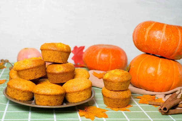 Mevsimlik balkabağı ve tarçın baharatlarıyla balkabağı kekleri pişirmek. Hem de yukarıdan. Balkabağı ve sarı yapraklı sonbahar kompozisyonu.