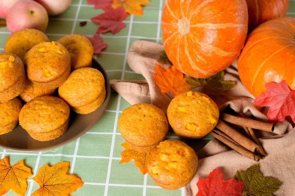 Mevsimlik balkabağı ve tarçın baharatlarıyla balkabağı kekleri pişirmek. Hem de yukarıdan. Balkabağı ve sarı yapraklı sonbahar kompozisyonu.