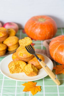 Şükran günü için balkabaklı kek ve balkabağı. Balkabağı ve akçaağaç yapraklarından oluşan bir sonbahar kompozisyonu. Kek parçalara ayrıldı..