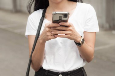 Genç bir kadın bir akıllı telefon kullanıyor