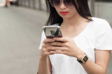 Genç bir kadın bir akıllı telefon kullanıyor