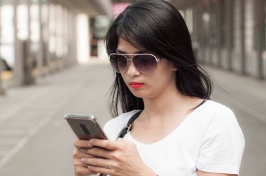 Genç bir kadın bir akıllı telefon kullanıyor