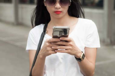 Genç bir kadın bir akıllı telefon kullanıyor