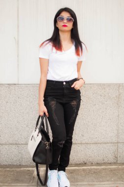 Şehir kaldırıma el çantası ile genç bir kadın portresi