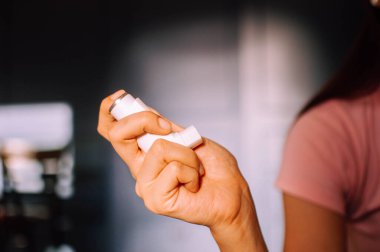 Genç bir kadın astım spreyi kullanıyor.