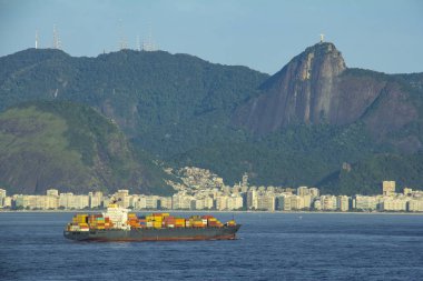 Rio de Janeiro İsa heykeli ile arka planda Redeemer, dağlar, tepeler ve Copacabana Plajı gelen kargo gemisi 
